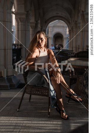 Woman, Chair, Cafe - A woman sitting in a chair in a cafe during the daytime. Woman, Chair, Cafe - A woman sitting in a chair in a cafe during the daytime. 136233486