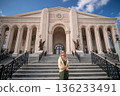 Woman Standing Building Azerbaijan - A woman stands in front of a grand building with columns in Azerbaijan. 136233491