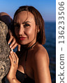 Woman portrait ocean. Beautiful woman posing by rock with sea background, enjoying nature 136233506
