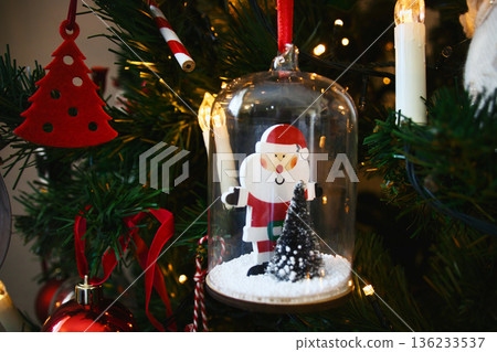 A close-up shot of a Santa encased in glass hanging Christmas tree decoration 136233537