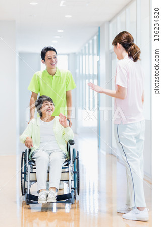 Image of a senior woman in a wheelchair and a caregiver 136234820