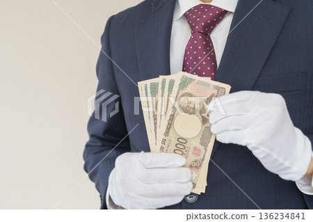 A man in a suit wearing white gloves and counting cash │ Image of purchase assessment A man in a suit wearing white gloves and counting cash │ Image of purchase assessment 136234841