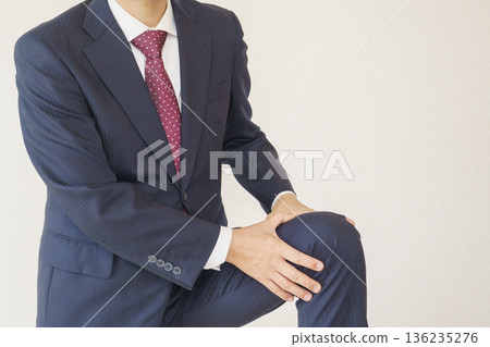 Image of a man in a suit with knee pain Image of a man in a suit with knee pain 136235276