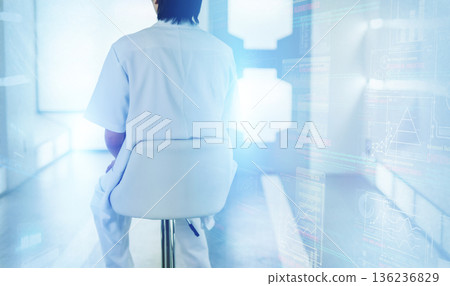 一個身穿白大褂的人背對著鏡頭，坐在椅子上，置身於充滿未來感的空間。 136236829