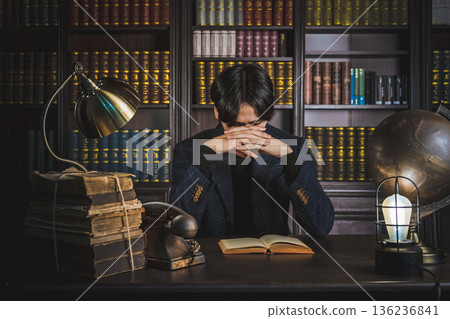 Deep in the study surrounded by old books and antique furniture 136236841