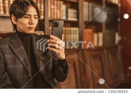 A Japanese man operating a smartphone in a luxurious study 136236845