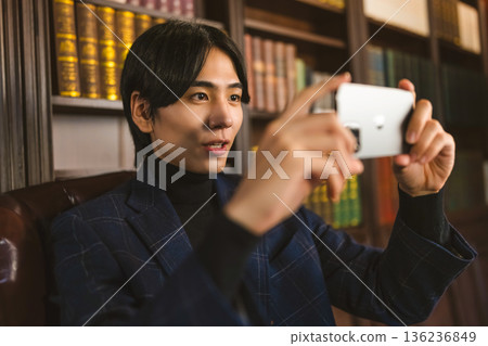 Shooting a video using a smartphone in the study 136236849