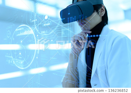 一位身穿白大褂的日本男性研究員戴著VR眼鏡思考。 136236852