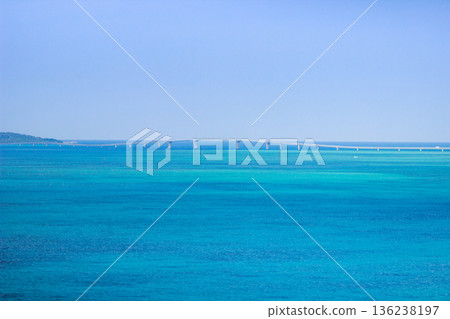 A long bridge stretching across the emerald blue sea under a blue sky 136238197