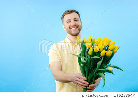 Man holding bouquet of flowers in front of face Man holding bouquet of flowers in front of face 136238647