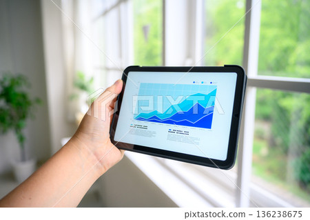 Checking business performance on a tablet 136238675