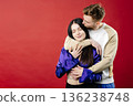 Shocked lady and positive man holding white fresh tulips, looking at camera isolated on blue background 136238748