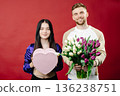 Smiling bearded man giving bouquet of flowers and gift box for beautiful woman. Portrait of happy romantic couple celebration birthday isolated on background 136238751