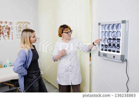 Doctor explaining spinal MRI results to patient Doctor explaining spinal MRI results to patient 136238863
