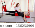 Woman receiving physical therapy suspension training rehabilitation 136238909