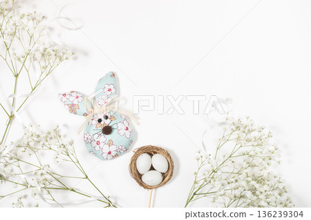 Flat lay Easter composition. Decorative bunny with eggs and flowers on white background Copy space Flat lay Easter composition. Decorative bunny with eggs and flowers on white background Copy space 136239304