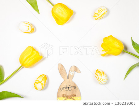 Easter decoration with wooden bunny, yellow tulips, and painted eggs on white top view Easter decoration with wooden bunny, yellow tulips, and painted eggs on white top view 136239305