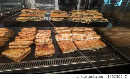 Cheese pies, spinach pies, and croque monsieur in the showcase 136239347