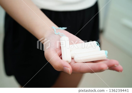 Asian woman holding cotton tampons for hygiene menstrual period cycle protection. 136239441