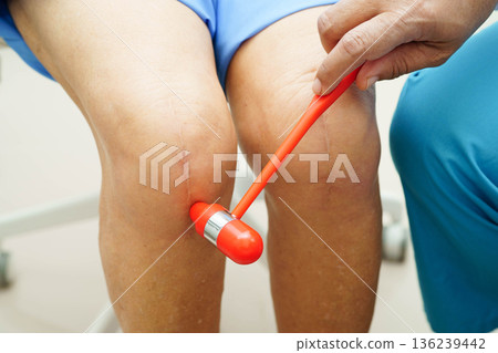 Asian doctor knock on knee reflex nerve for check and treatment senior patient in hospital. 136239442