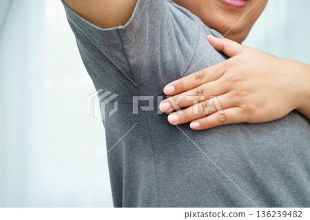 Sweaty underarms, Asian woman with sweat on clothes under armpit. Sweaty underarms, Asian woman with sweat on clothes under armpit. 136239482