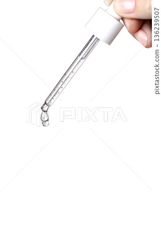 Pipette with serum in hand. Drips drop isolated on white background, copy space vertical photo close up 136239507