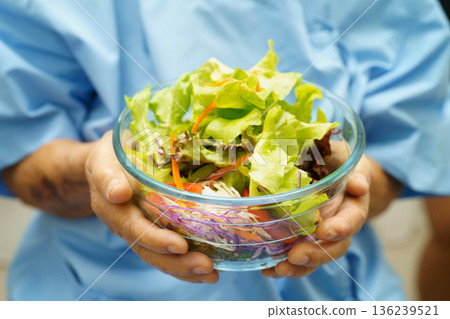 Asian elderly woman patient holding healthy food for patient in hospital, nutrition and vitamin. Asian elderly woman patient holding healthy food for patient in hospital, nutrition and vitamin. 136239521