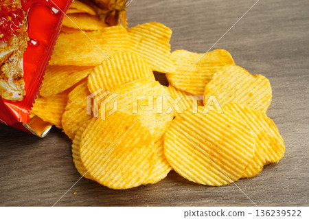 Potato chips in open bag, delicious BBQ seasoning spicy for crips, thin slice deep fried snack fast food. 136239522