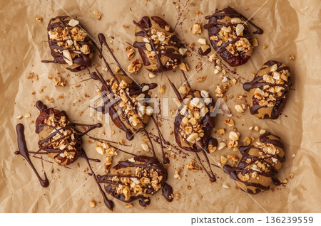 Viral date bark snack with peanut butter and chocolate drizzle on parchment paper Viral date bark snack with peanut butter and chocolate drizzle on parchment paper 136239559
