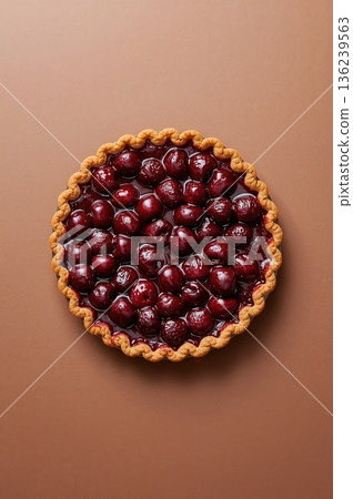 Fresh baked cherry pie centered on brown background top down food photo 136239563
