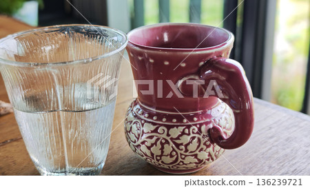 A glass of water and a coffee cup are on the table. A glass of water and a coffee cup are on the table. 136239721