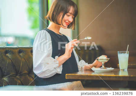Young woman enjoying ice cream in a cafe Young woman enjoying ice cream in a cafe 136239876