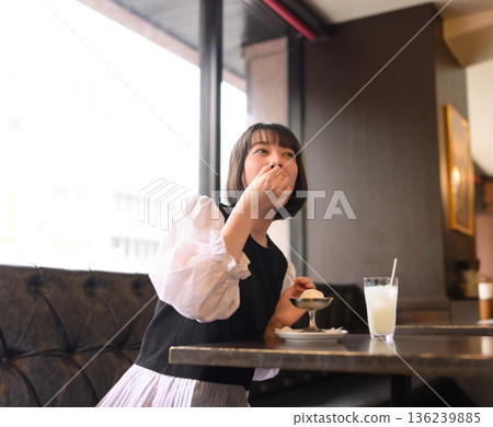 A Japanese woman in her twenties enjoying ice cream at a cafe 136239885