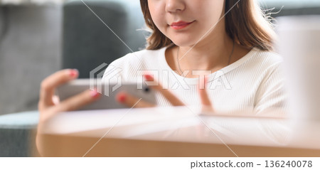 A woman operates a smartphone A woman operates a smartphone 136240078