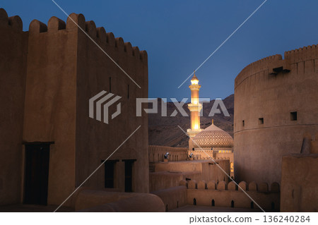 Nizwa Fort tower and Al Qalaa Mosque illuminated at night in Oman Nizwa Fort tower and Al Qalaa Mosque illuminated at night in Oman 136240284