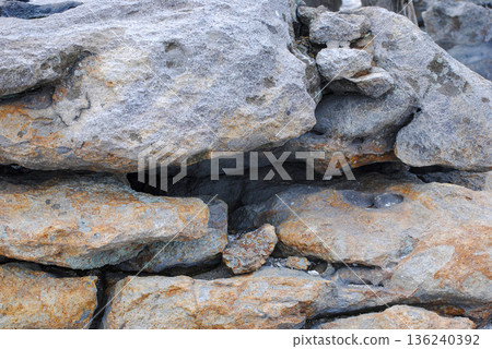 Large boulders and rugged volcanic rocks scattered on a steep mountain slope in the Kuril Islands. Large boulders and rugged volcanic rocks scattered on a steep mountain slope in the Kuril Islands. 136240392