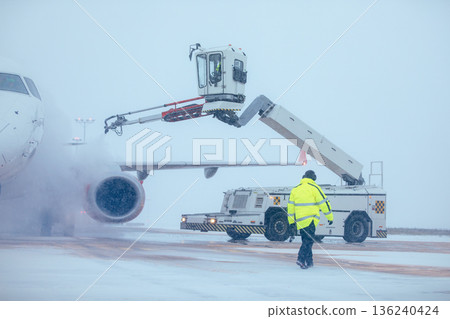 Deicing of airplane before flight at airport 136240424