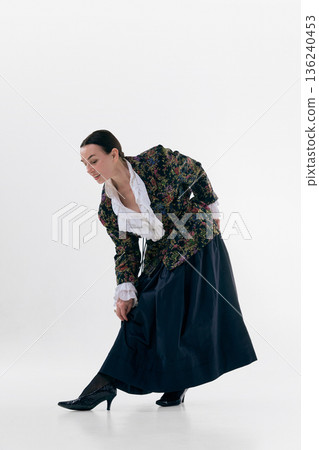 Elegant mature woman bending forward in floral jacket with playful natural emotion. 136240453