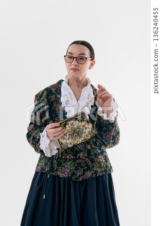 Elegant mature poetcore woman holding vintage purse. 136240455