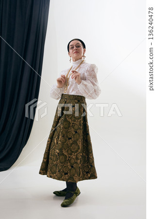 Elegant vintage woman showing classic outfit in studio. Elegant vintage woman showing classic outfit in studio. 136240478