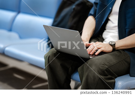 A man working on a PC at the airport. Photo courtesy of Kansai International Airport (KIX). 136240991