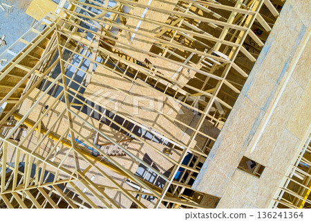 Workers assemble wooden beams frames on construction site for new building in city 136241364