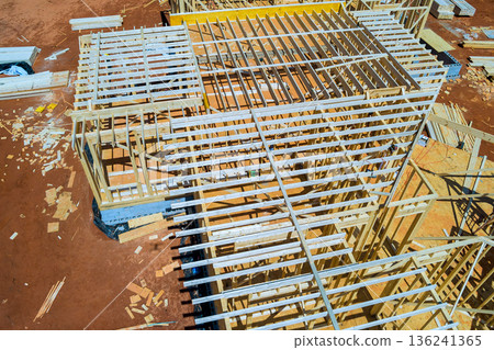 Workers build beams framing roof trusses with wooden frames materials on construction site 136241365