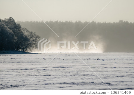 Blowing and drifting snow mist across a frozen lake Blowing and drifting snow mist across a frozen lake 136241409