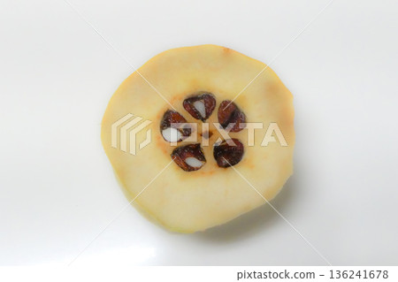A photo of a hard quince sliced into rings 136241678