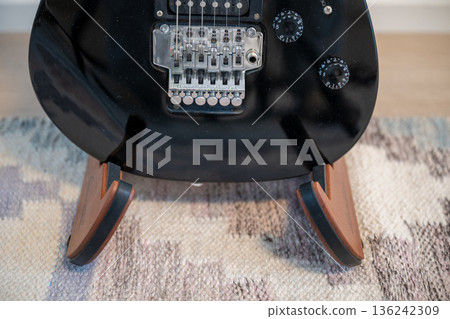 Electric guitar body detail with tremolo bridge on wooden stand 136242309
