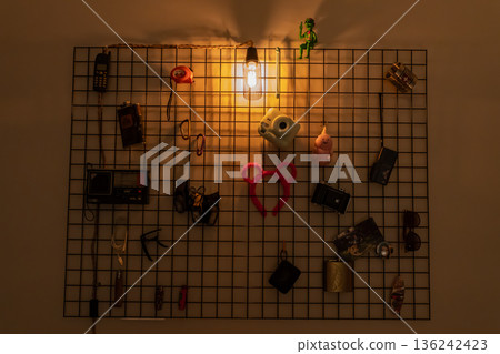 Decorative wall grid with warm Edison light and vintage items Decorative wall grid with warm Edison light and vintage items 136242423