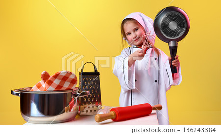 Young girl chef holding pan and whisk in studio Young girl chef holding pan and whisk in studio 136243384
