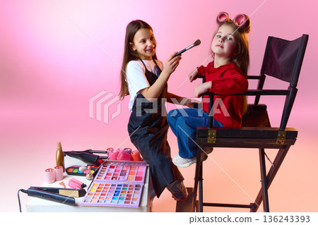 Two little girls playing makeup artist and model in studio Two little girls playing makeup artist and model in studio 136243393
