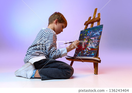 Child painting colorful abstract artwork on easel. Child painting colorful abstract artwork on easel. 136243404